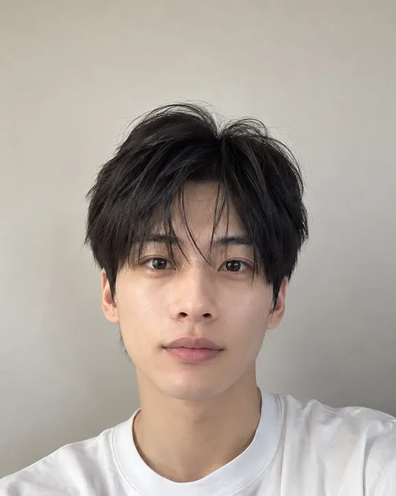 Young man with medium-length black hair and a messy fringe, the original photo
